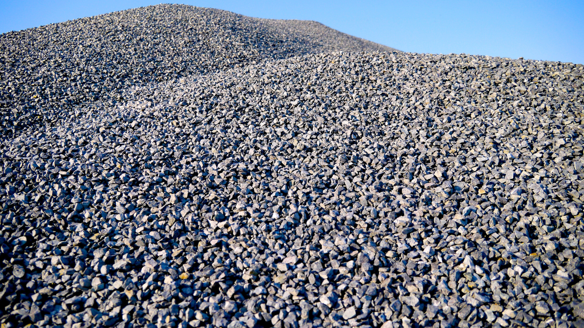 A large pile of gravel is sitting on top of a hill.