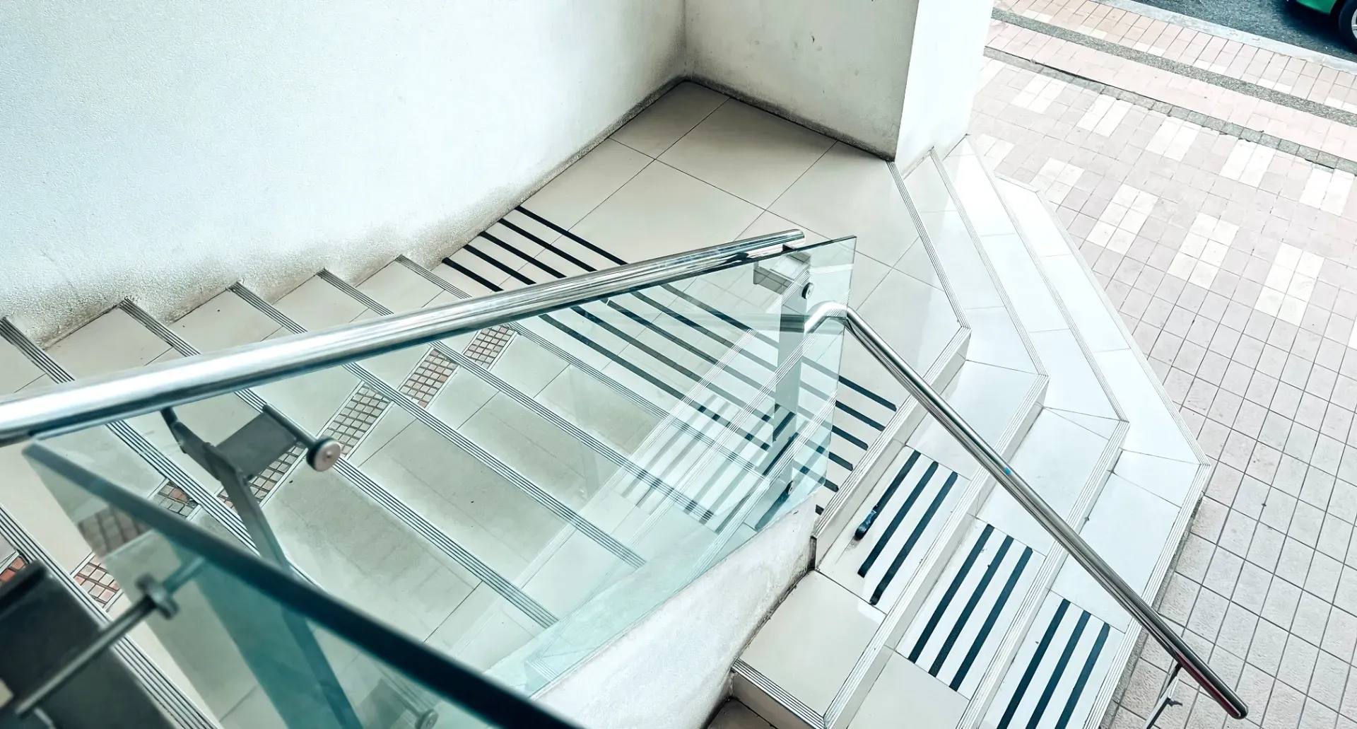 Glass-railed staircase with white steps and striped flooring in a bright indoor space — Channel Glazing In Electrona, TAS