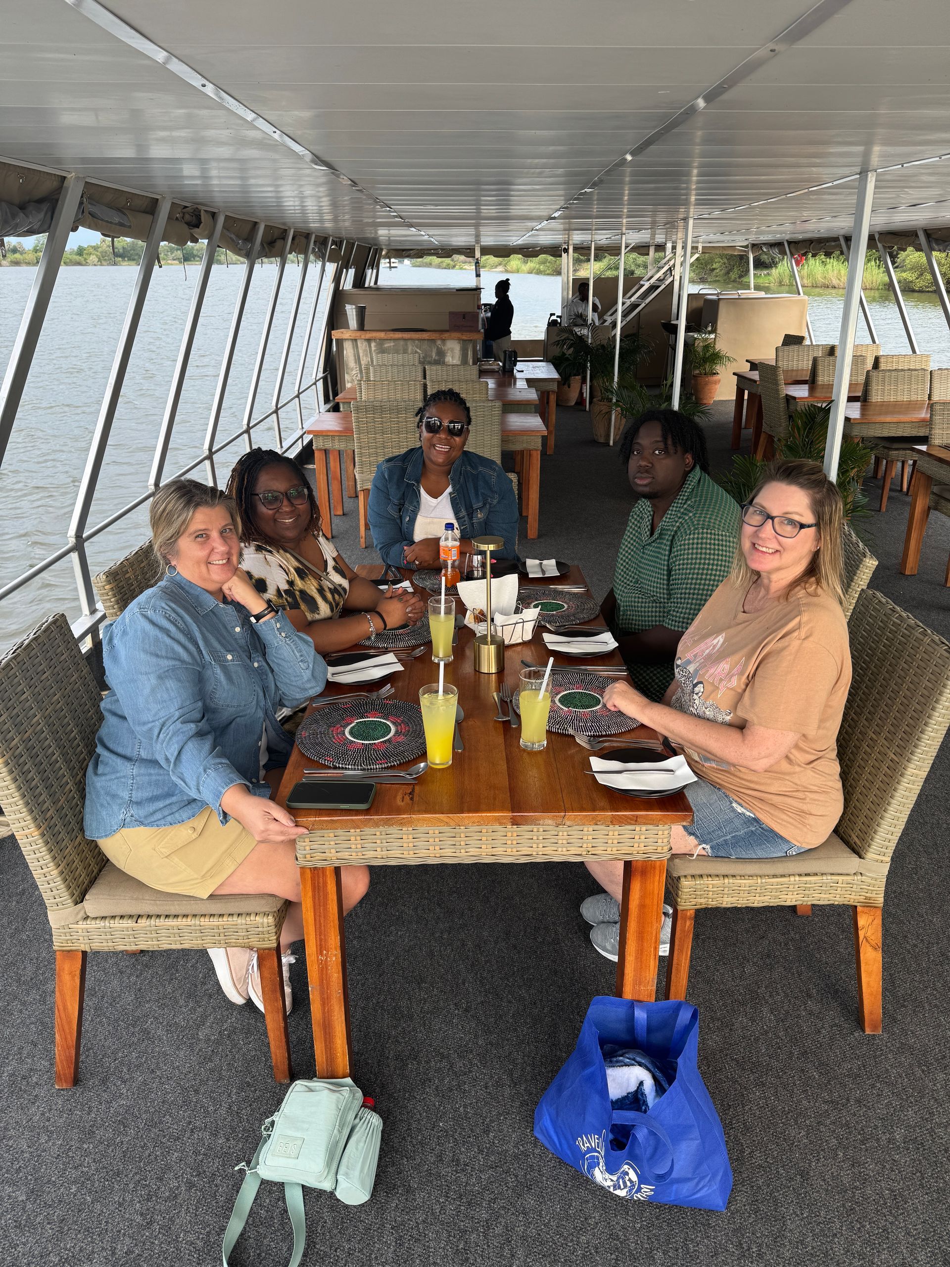 A group of people are sitting at a table on a boat.