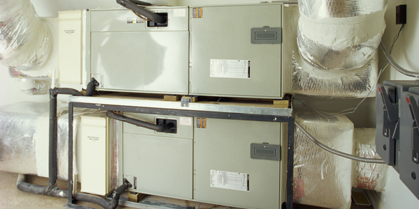 Industrial HVAC units with insulated ducts and piping in a utility room