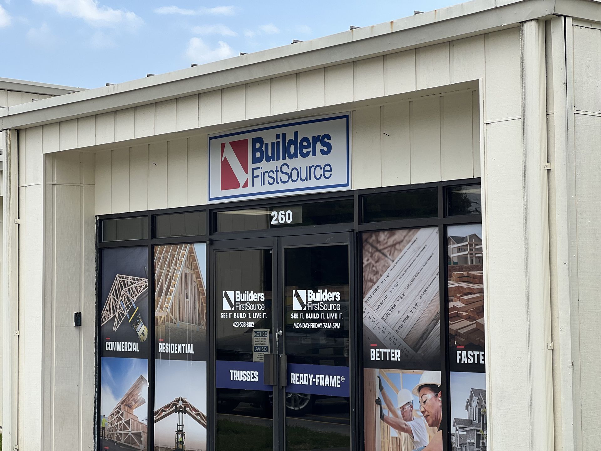 Builders FirstSource store entrance with signage and window displays.