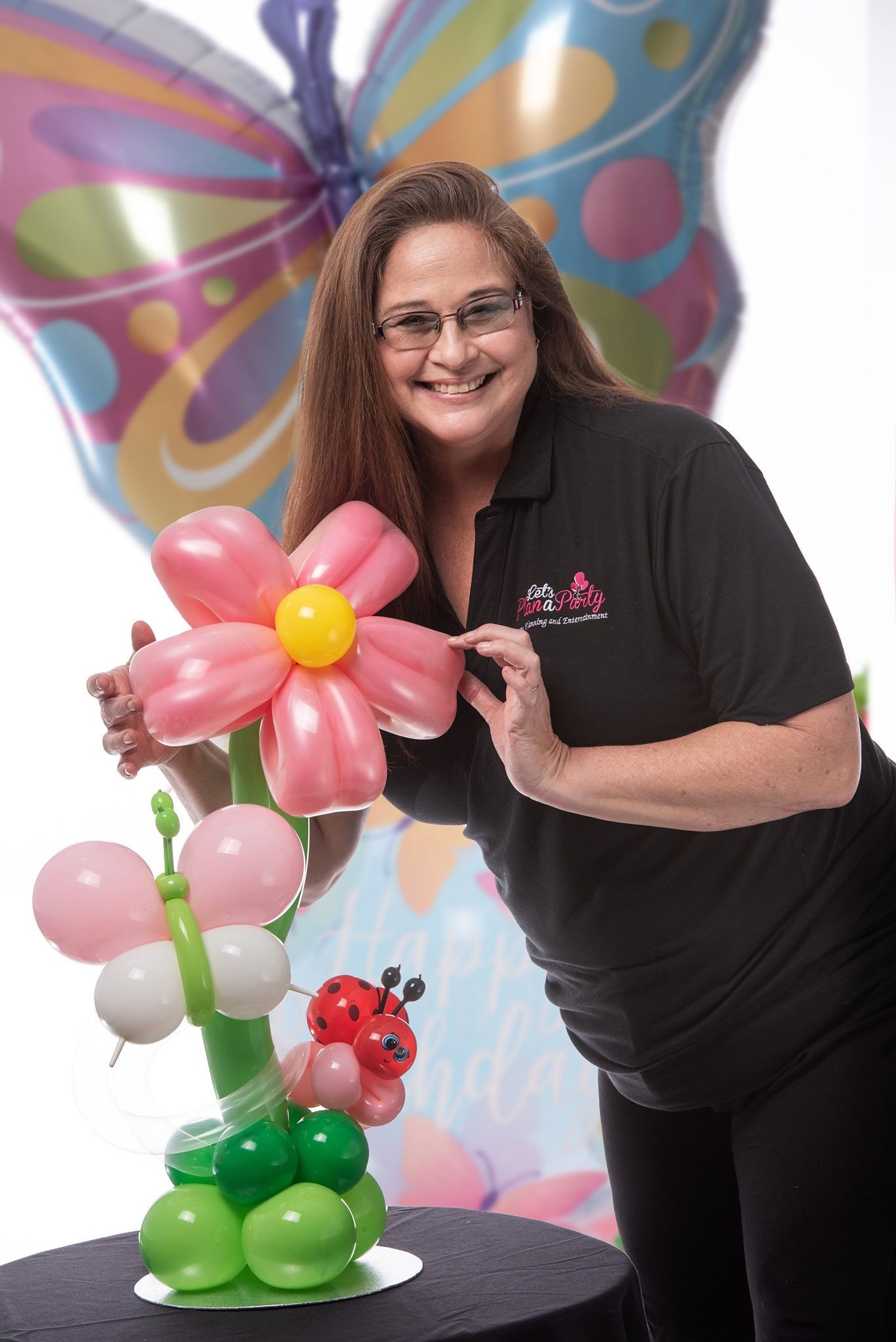 a woman is standing next to a flower made out of balloons