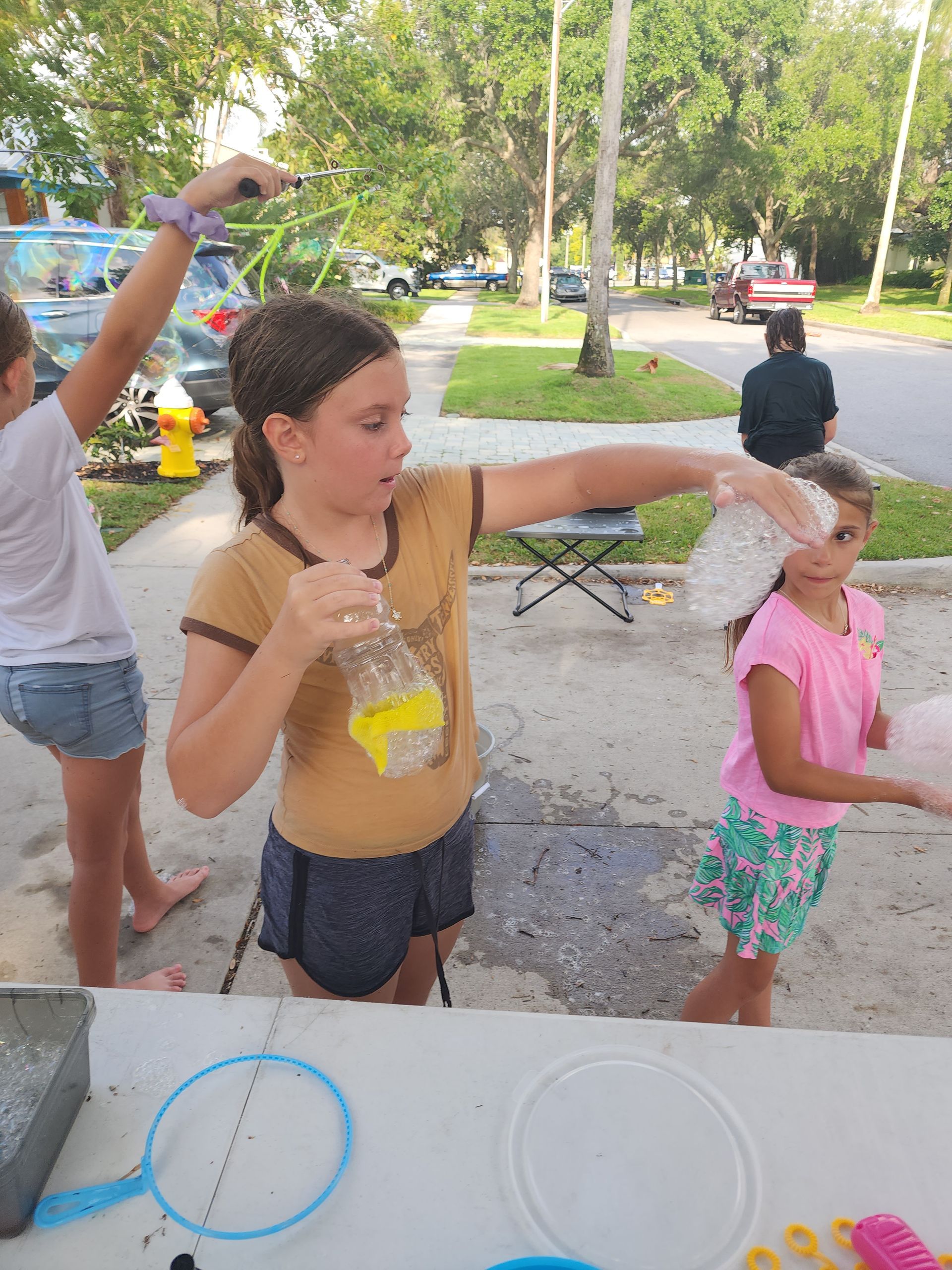 A group of young girls are playing with bubbles at a table.