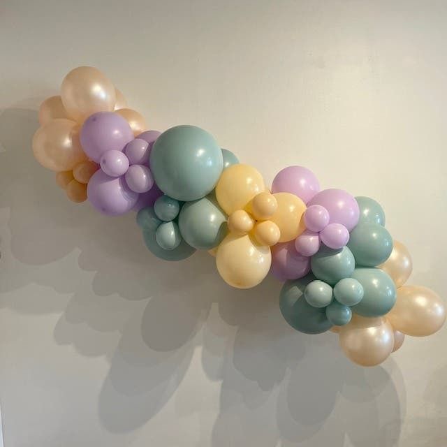 A bunch of balloons are hanging on a wall.