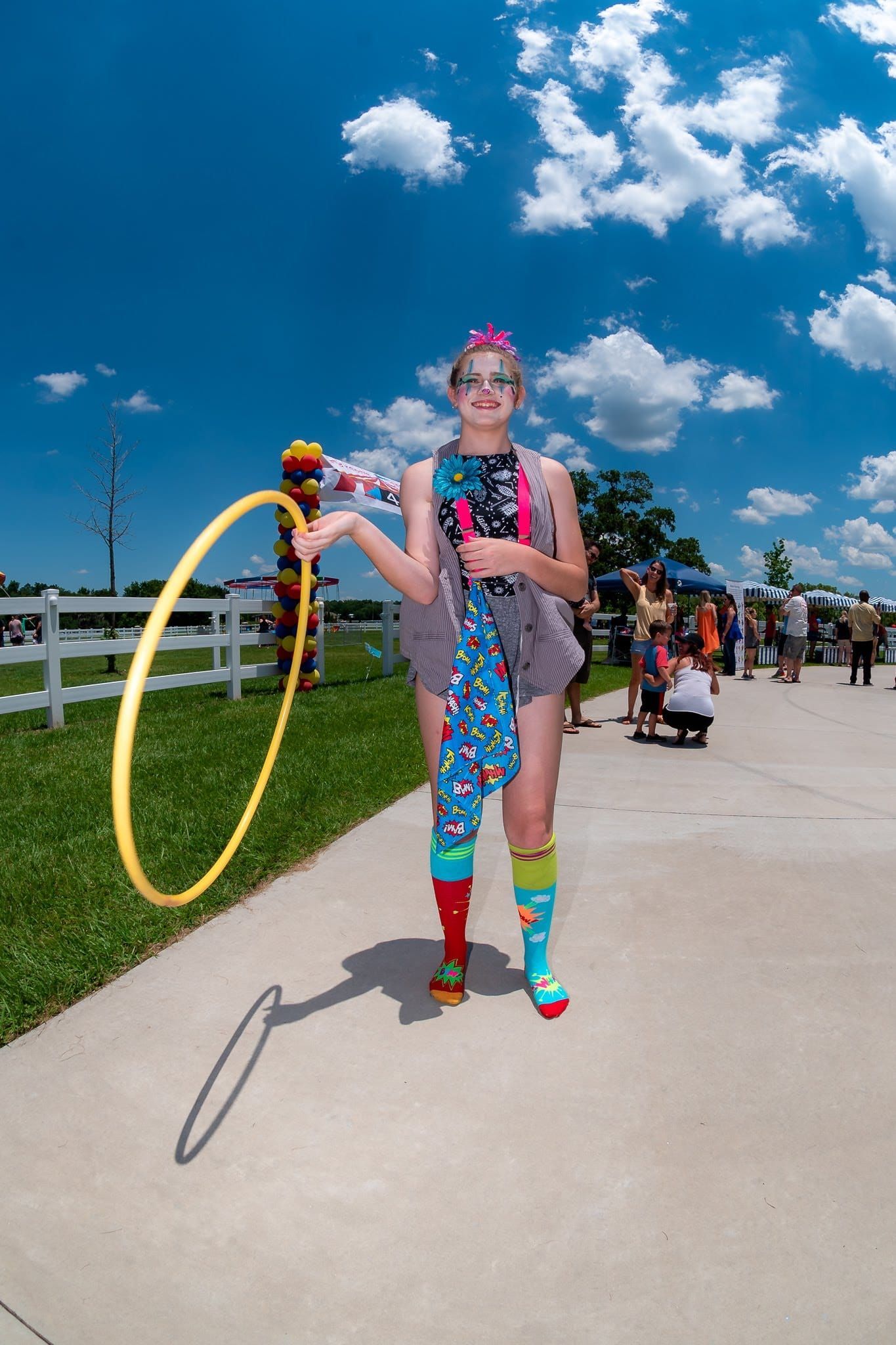 A woman with a prosthetic leg is holding a yellow hula hoop.