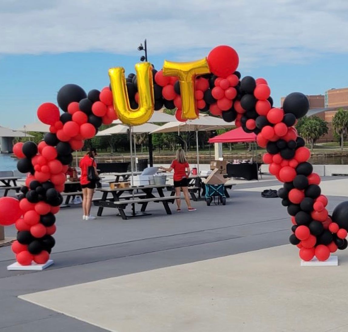 A red and black balloon arch with the word ut on it