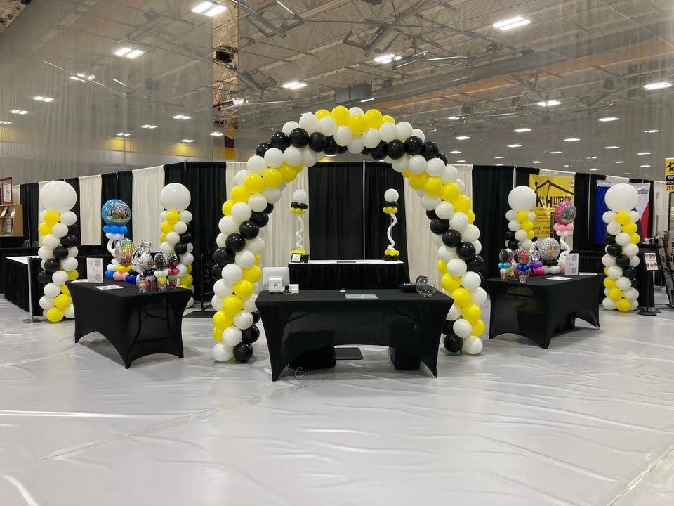 A large room filled with balloons and tables.