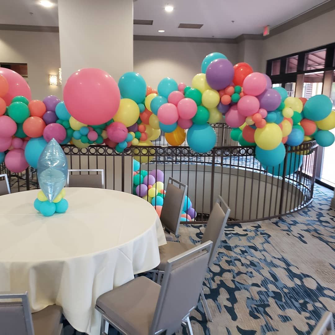 A room with a table and chairs decorated with balloons