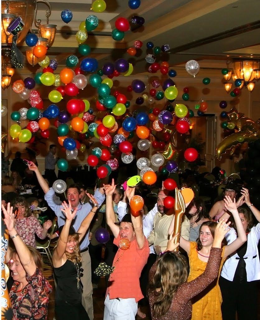A group of people are throwing balloons in the air