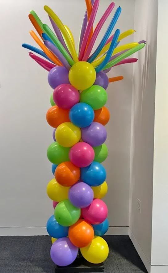 A bunch of colorful balloons are stacked on top of each other