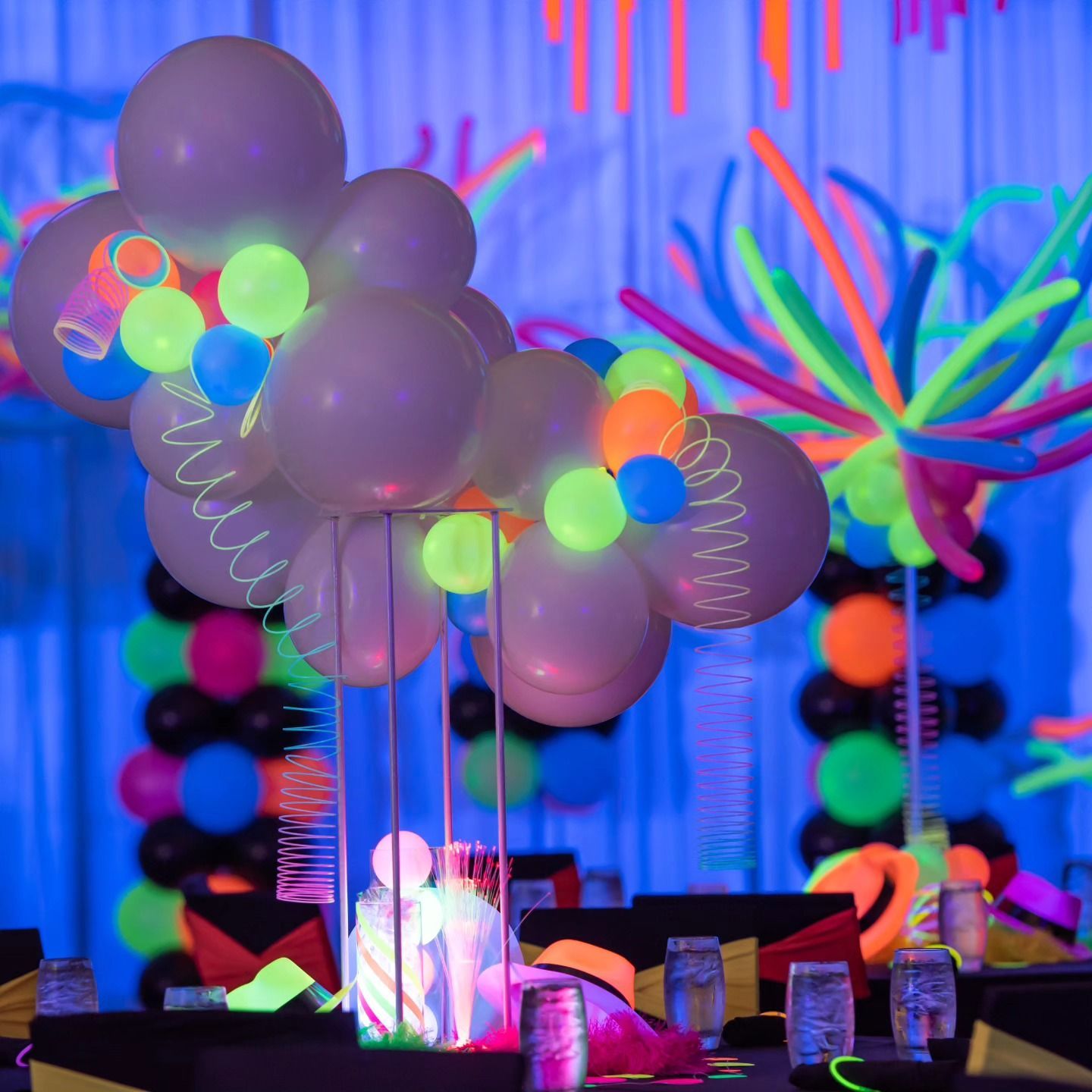 A bunch of balloons are glowing in the dark