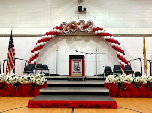 A stage decorated with balloons and the year 2023
