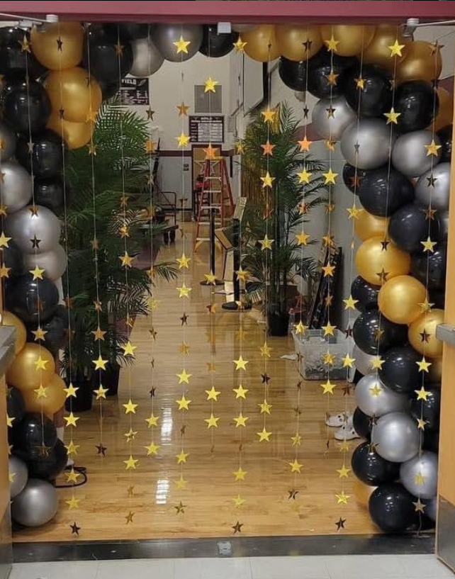 A hallway with balloons and stars hanging from the ceiling