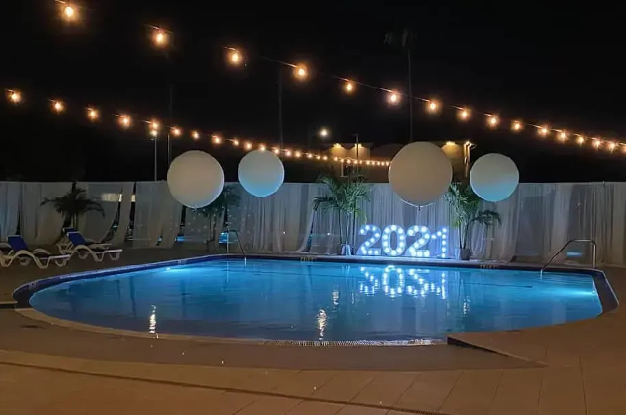 A swimming pool decorated for the new year 's eve with balloons and lights.