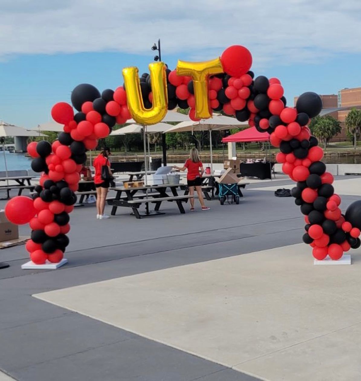 A red and black balloon arch with the letter u on top