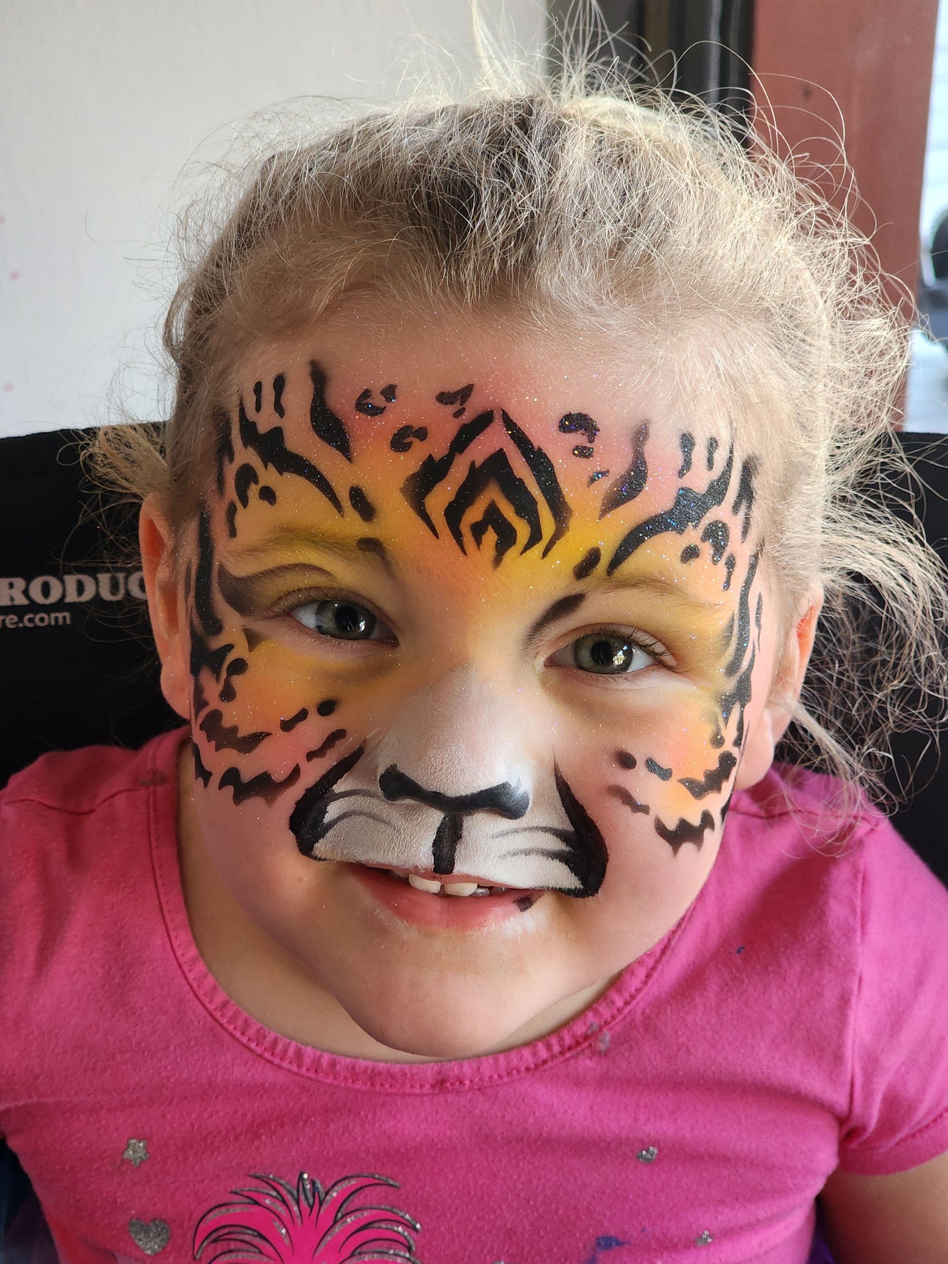 A little girl with her face painted like a tiger