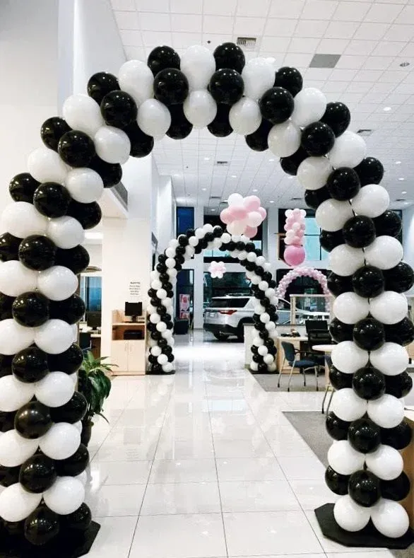A black and white balloon arch in a car dealership