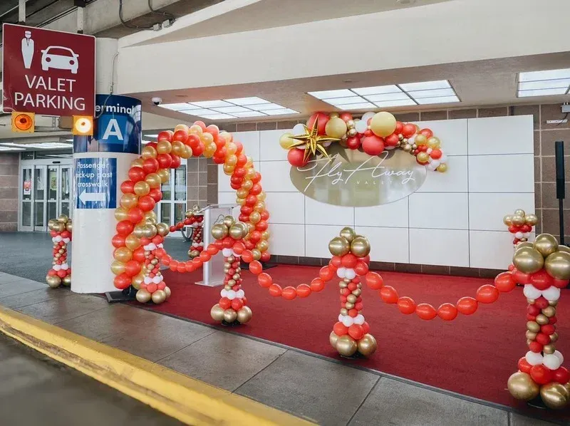 Balloons are lined up in front of a sign that says valet parking