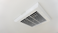 A white square ventilation fan installed on a matching textured ceiling.
