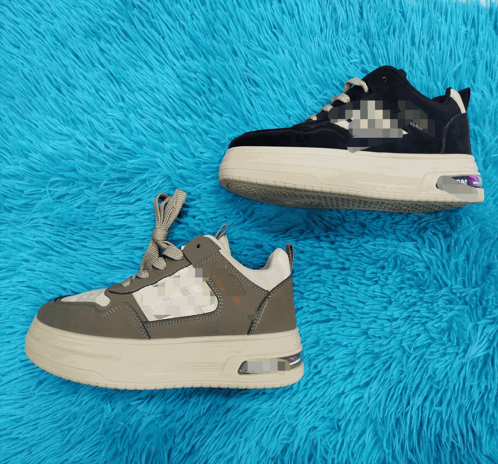 Dos zapatillas: una gris y otra negra, sobre una alfombra peluda azul.