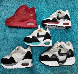 Cinco zapatillas de colores sobre una superficie azul esponjosa. Zapatillas rojas, blancas y negras con bolsas de aire.