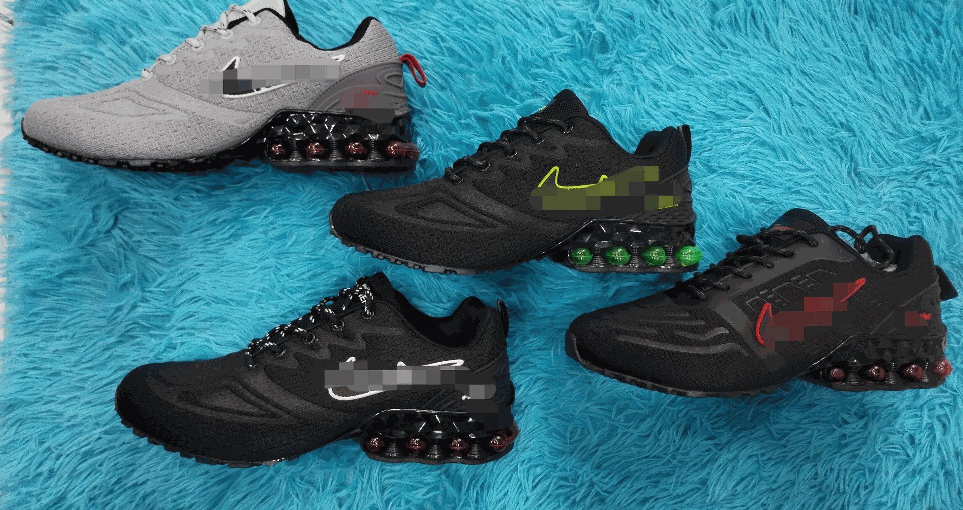 Cuatro pares de zapatillas deportivas Nike en varios colores negro y gris con una suela de burbuja única, dispuestas sobre una superficie texturizada azul.