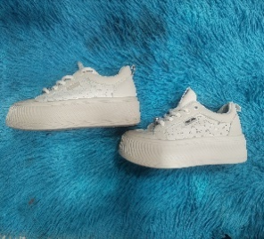 Zapatillas de plataforma blancas sobre una superficie esponjosa de color azul.