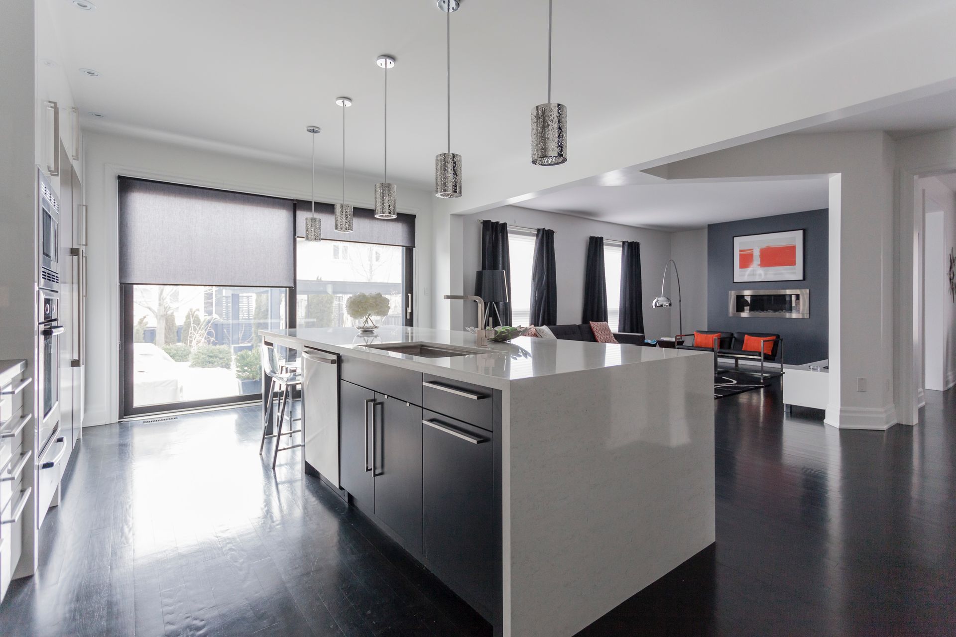 Spacious modern kitchen and living area with a large central island featuring a sink