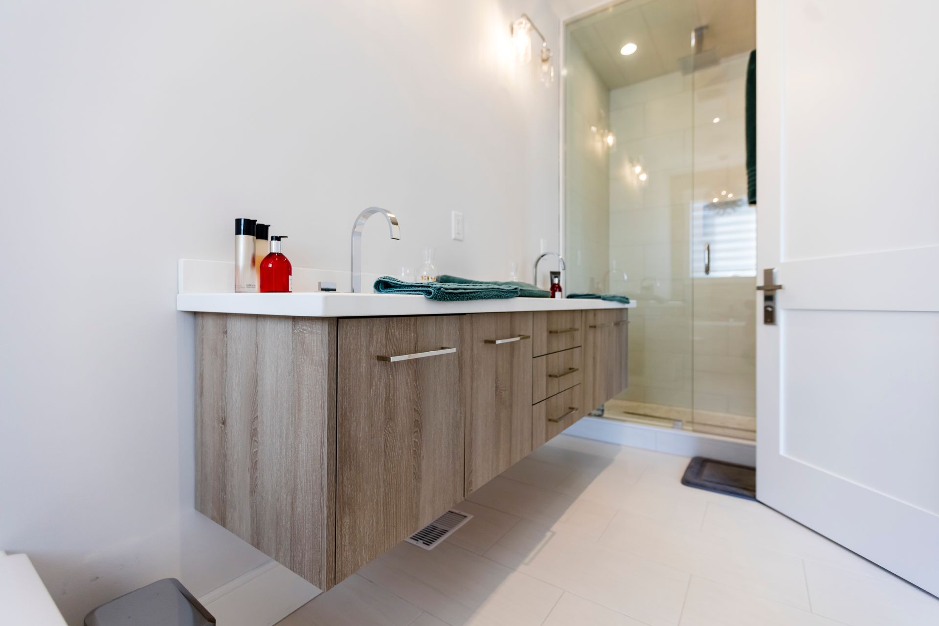 A bathroom with two sinks and a walk in shower.