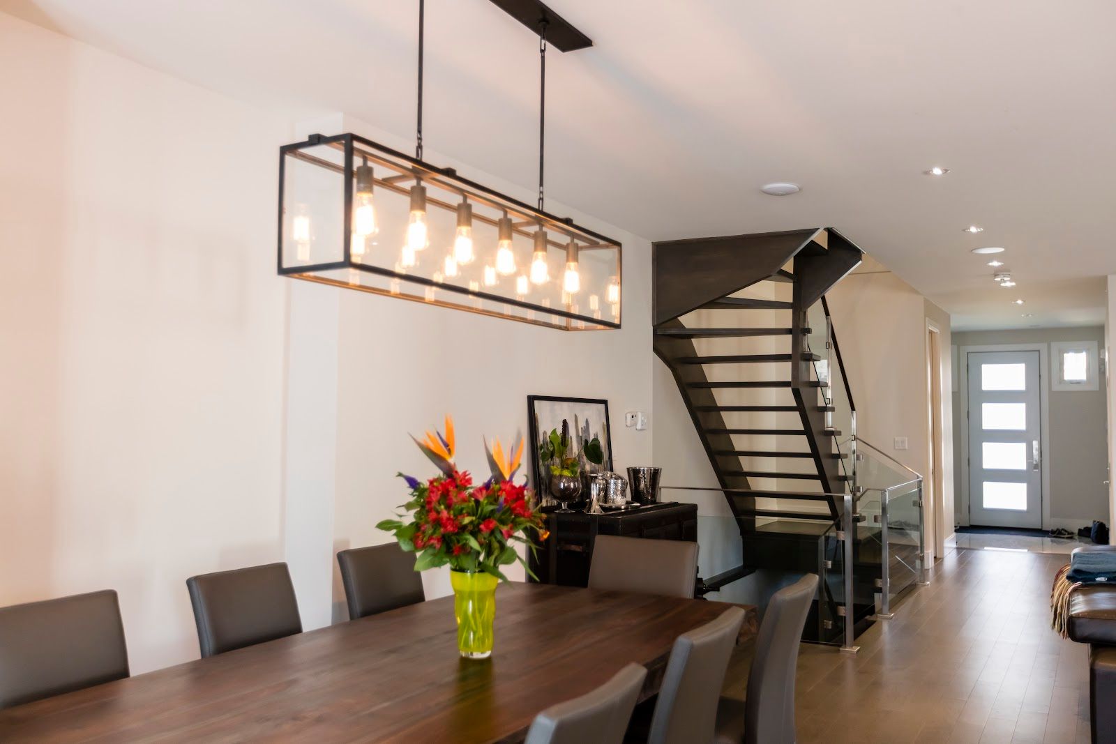 A dining room table with a vase of flowers on it