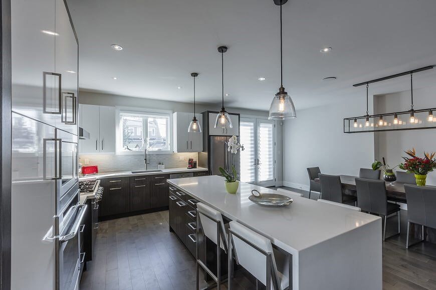 A kitchen with a large island and a dining room in the background.