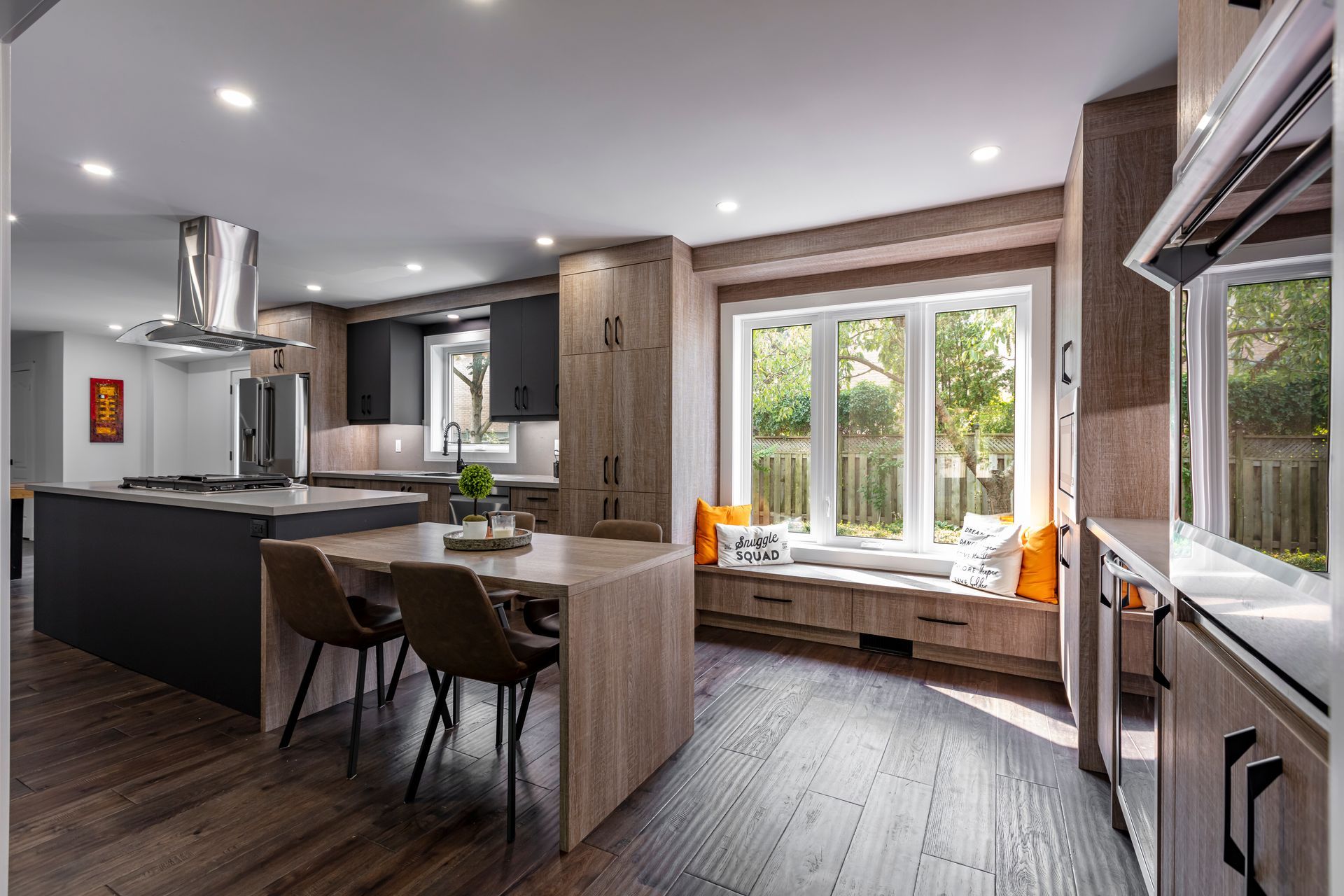 A kitchen with a table and chairs and a window seat.