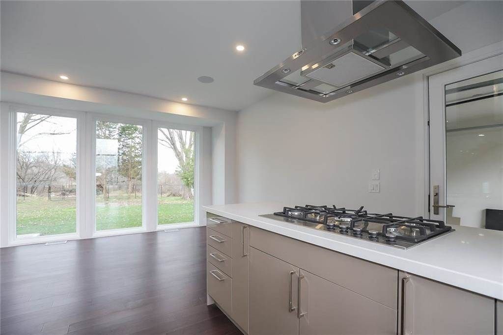 An empty kitchen with a stove top oven and a lot of windows