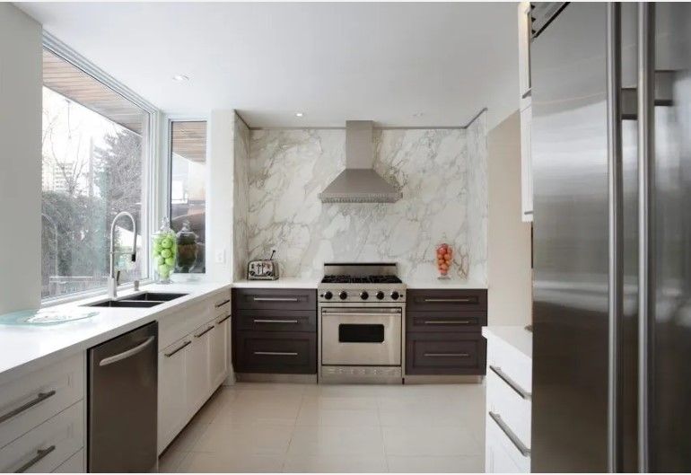 A kitchen with stainless steel appliances and white cabinets