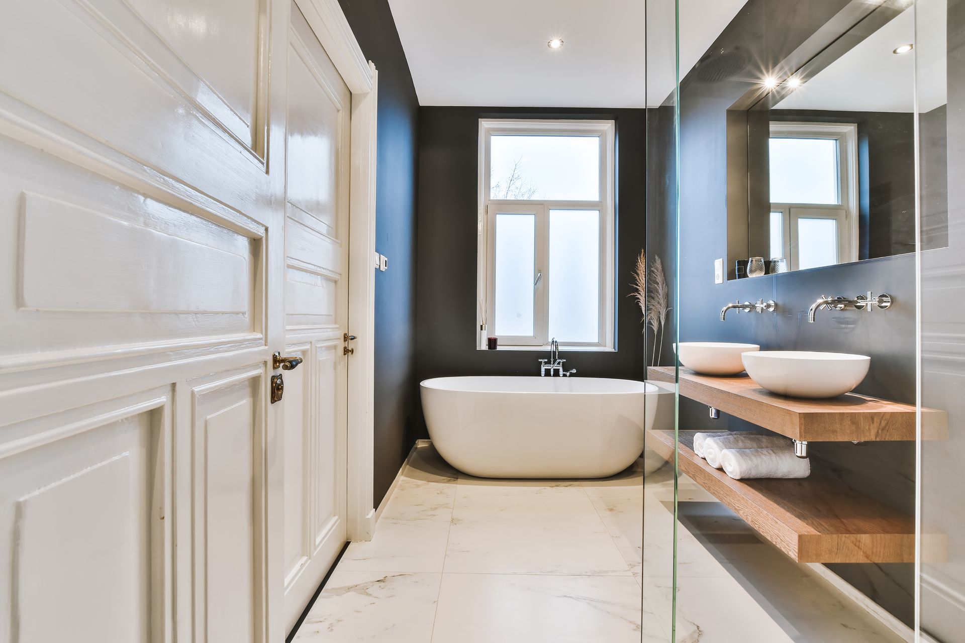 A bathroom with a bathtub , sinks , and a walk in shower.