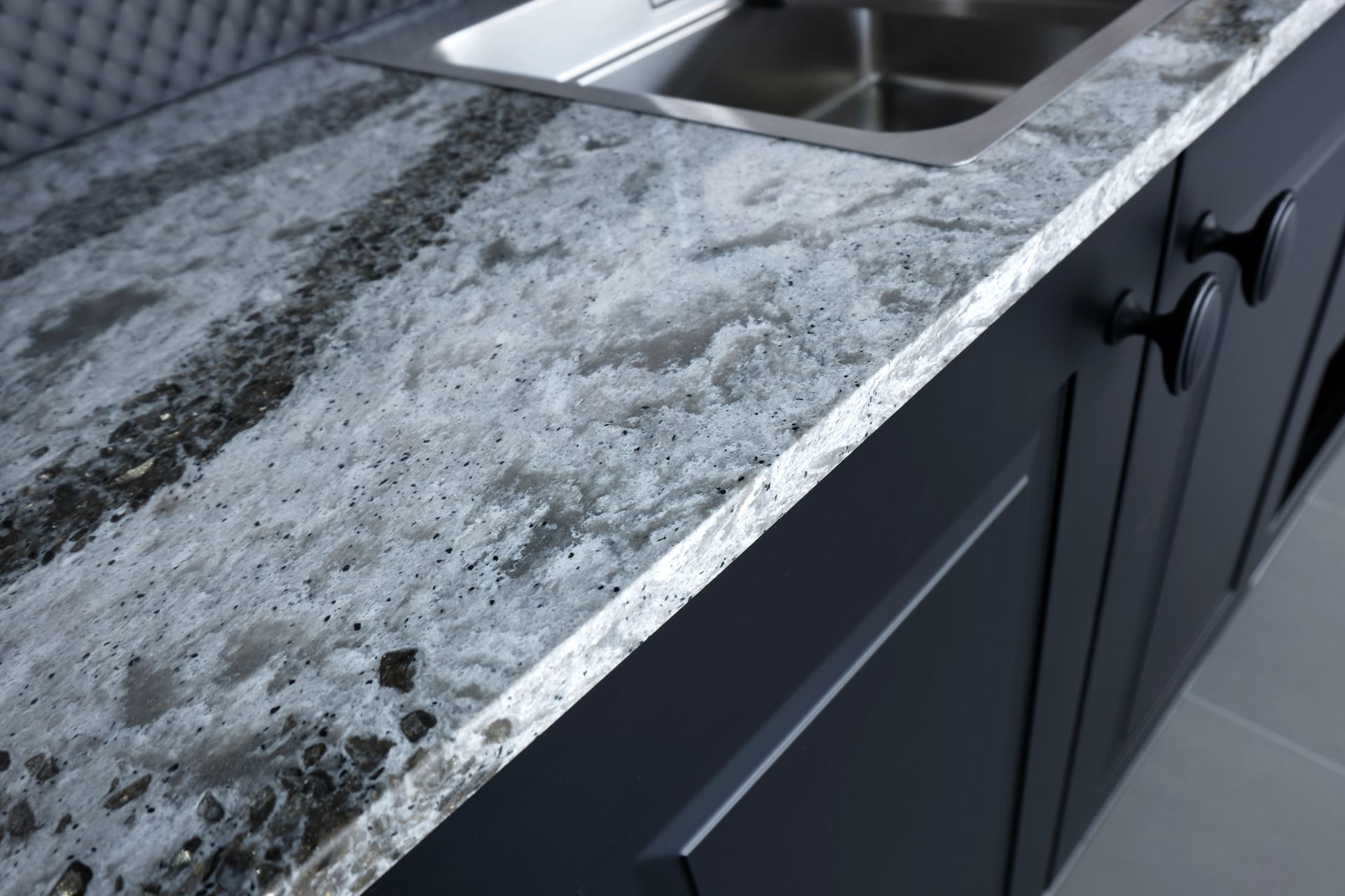 A kitchen counter with a sink and a granite counter top