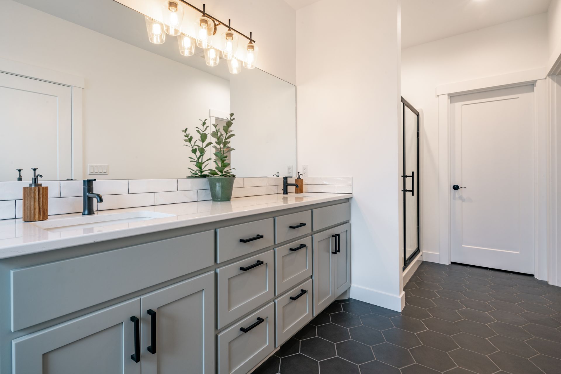 A bathroom with two sinks and a large mirror.