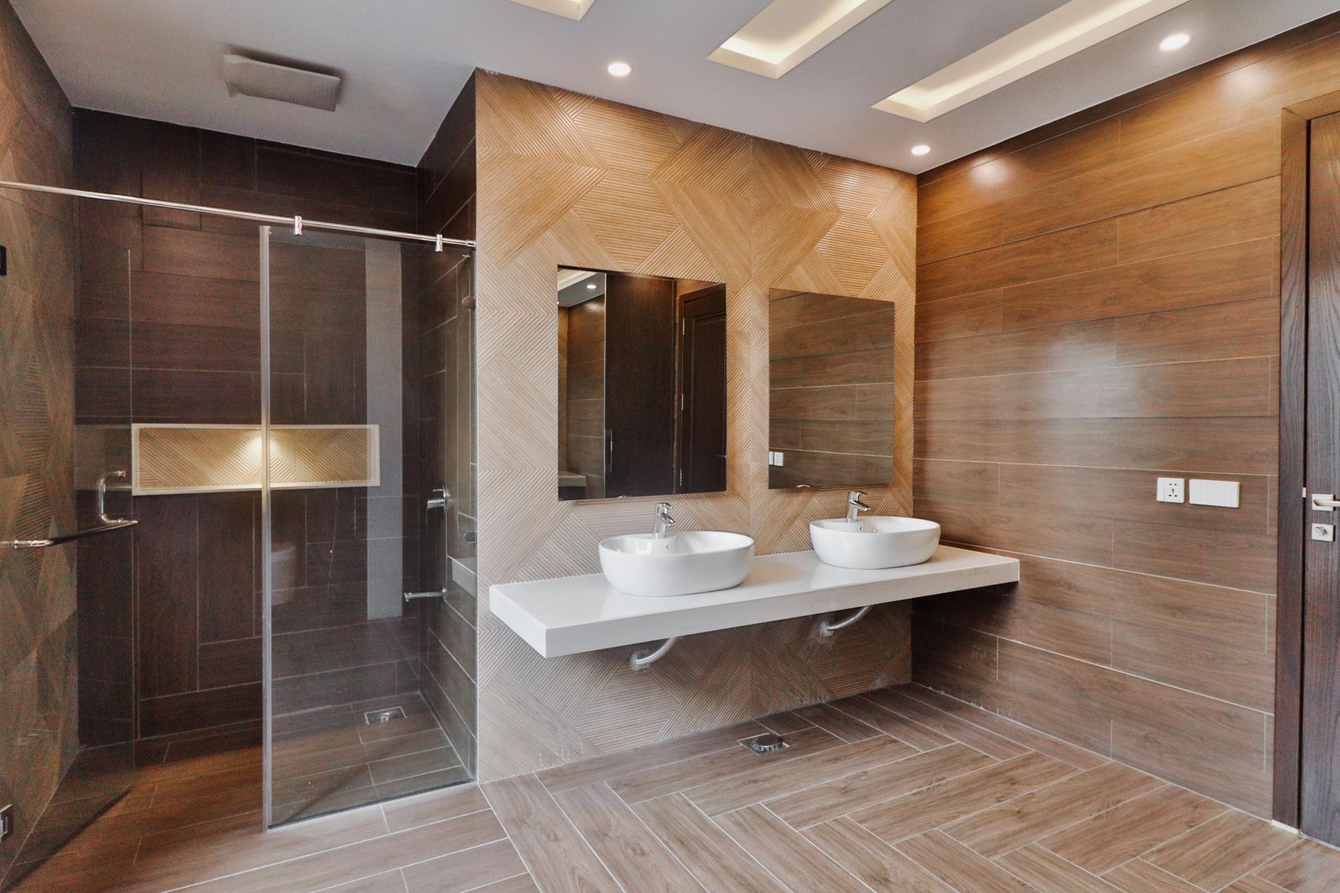 A bathroom with two sinks and a walk in shower.