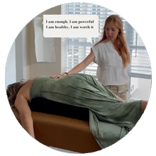 A woman is giving a massage to a woman who is laying on a table