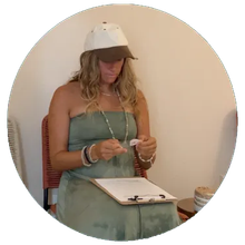 A woman wearing a hat is sitting in a chair with a clipboard