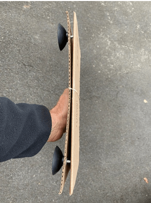 A person is holding a piece of cardboard with suction cups attached to it