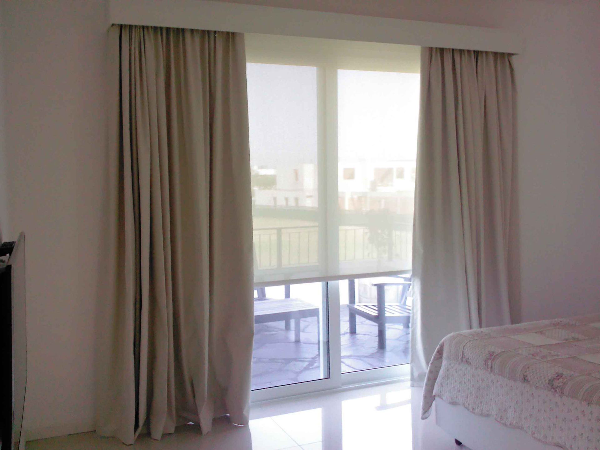 Un dormitorio con una cama y una puerta corrediza de vidrio.