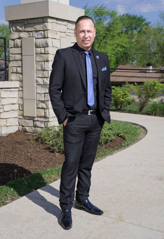 White kitchen with island, countertops, and seating. Dining table with window view.