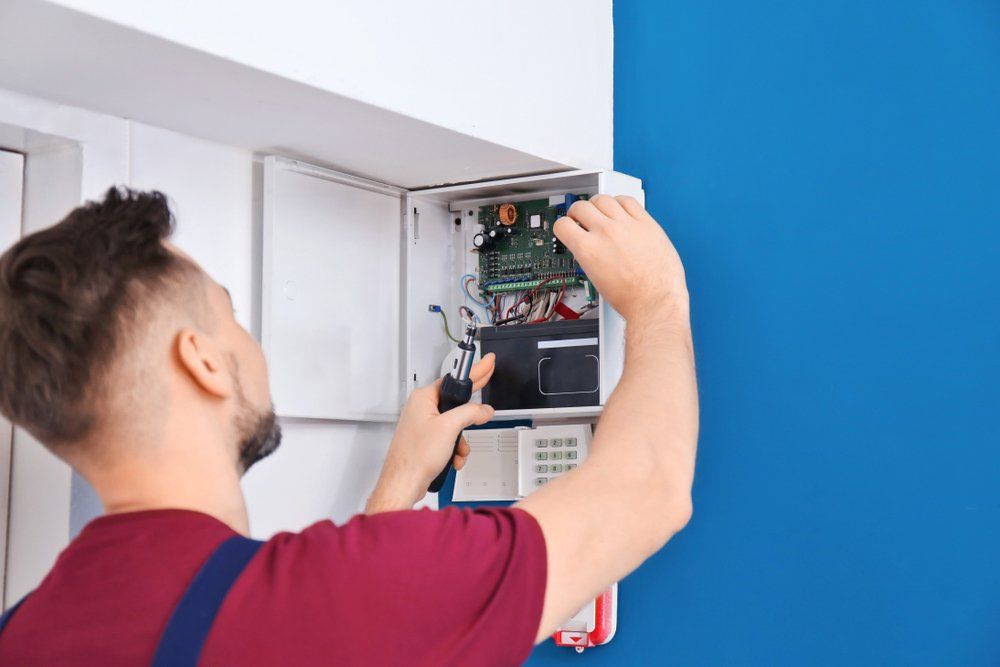 Electrician Installing Alarm System — Electricians In Bundaberg, QLD