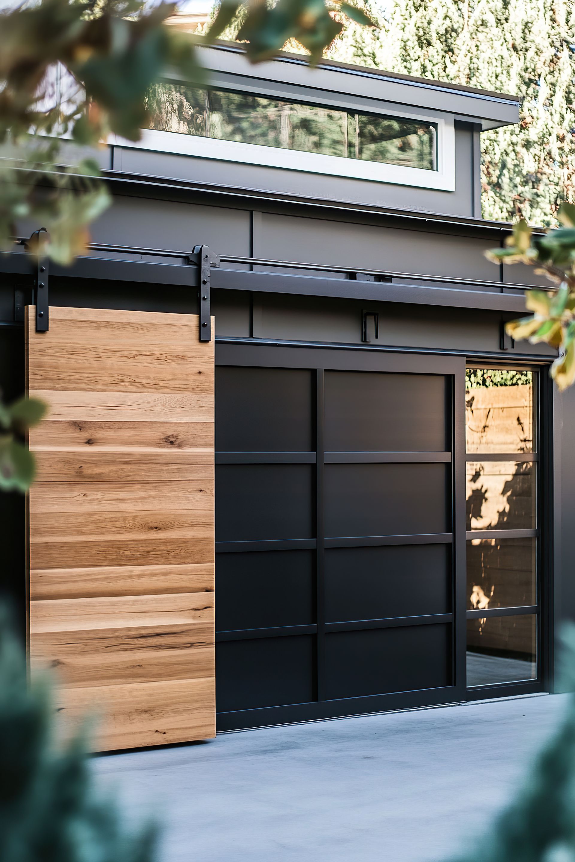 Wooden sliding barn door, dark garage door with black frame, contemporary style.