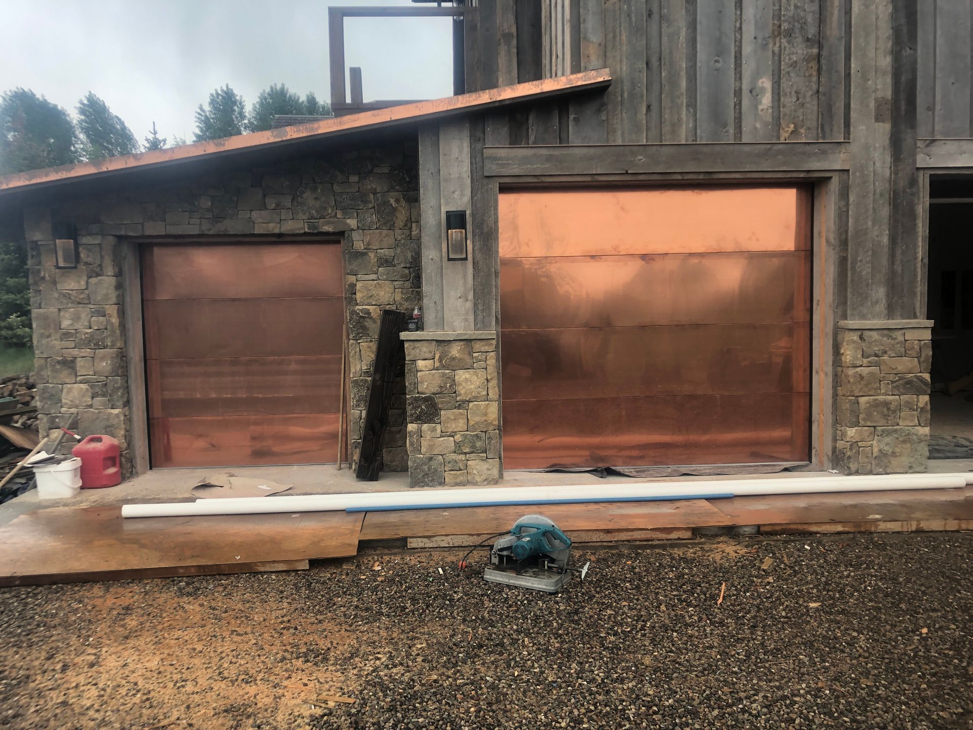 Copper garage doors on a stone and wood building, exterior shot.