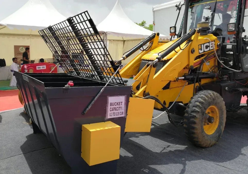 Yellow and gray industrial concrete mixer machine, outdoors, sunny.