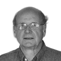 Man wearing glasses looking forward, close-up, black and white.