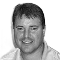 Smiling man with short dark hair, wearing a light-colored polo shirt.