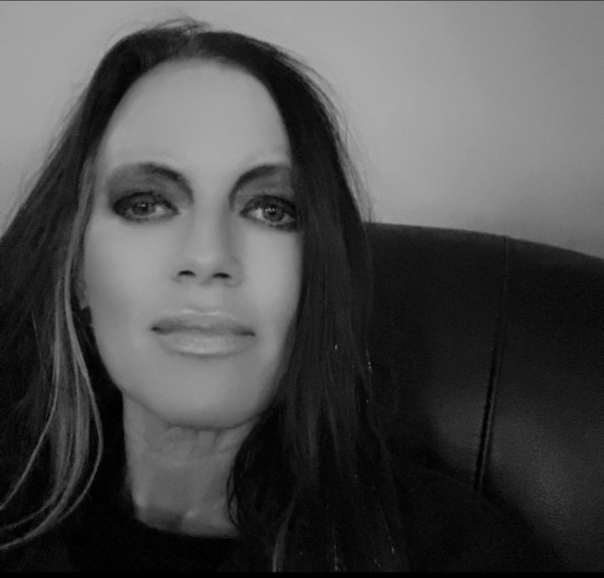 Man smiling, wearing a suit and tie, against a white background.